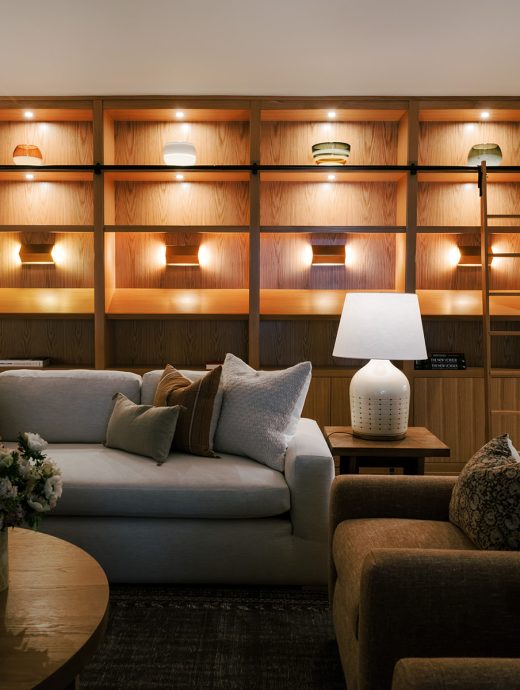 Illuminated book shelves in modern living room with white lamp